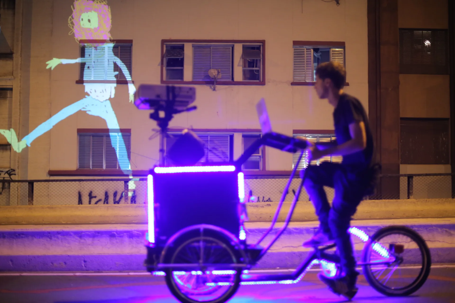 VJ Suave Suaveciclo conducting mobile projection mapping on a city wall