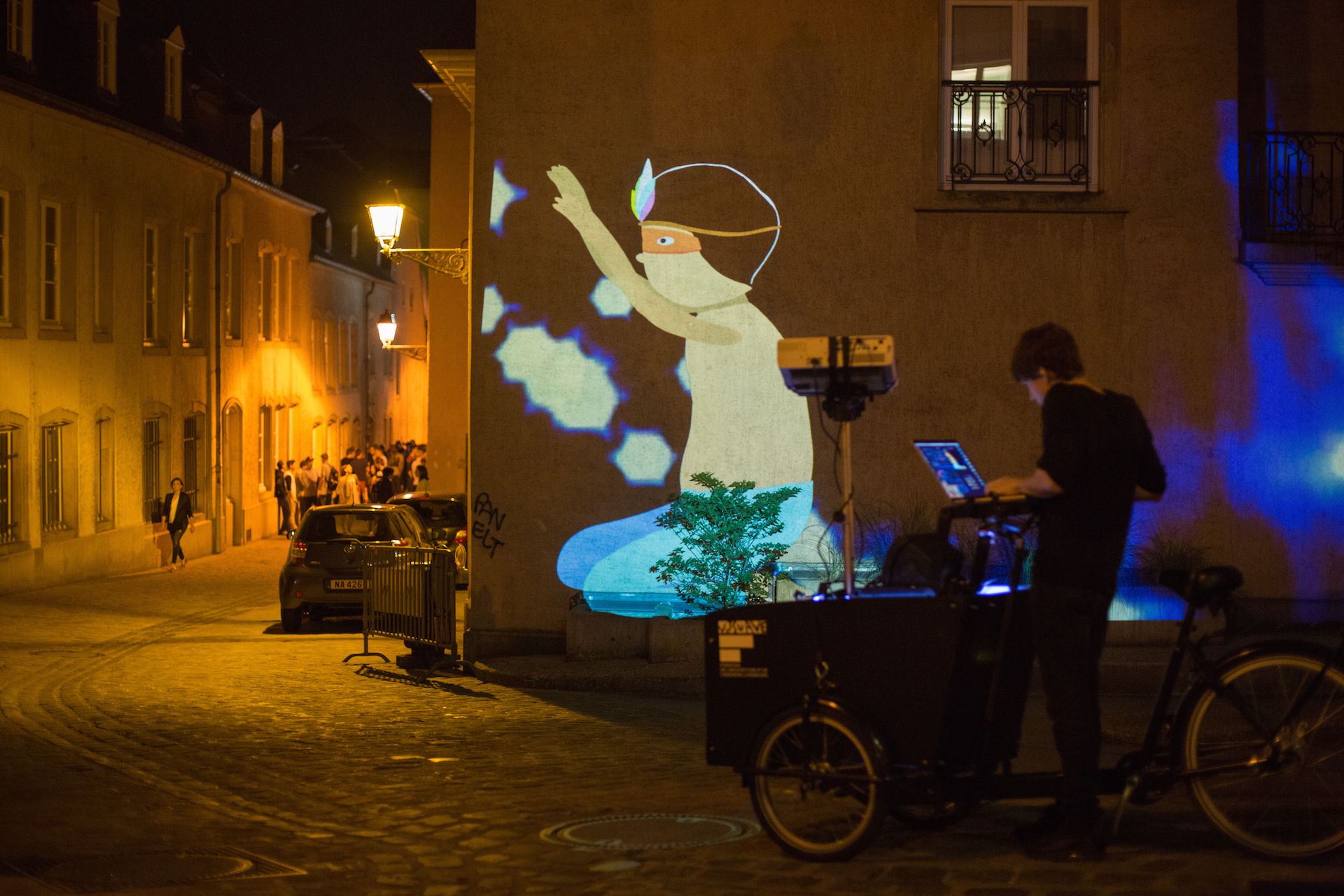 VJ Suave Suaveciclo conducting mobile projection mapping on a city wall